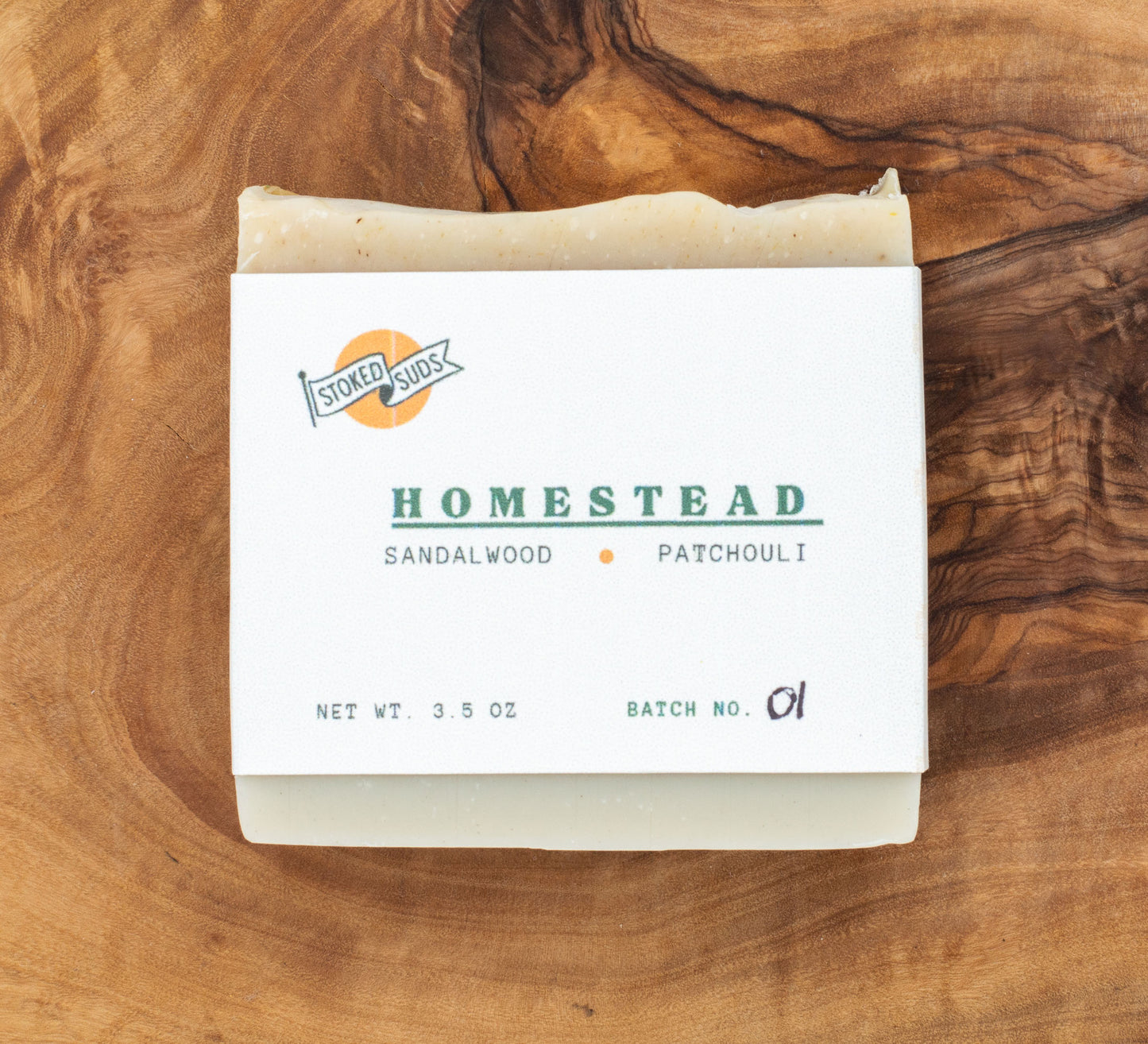 Bar of soap with 'Homestead' label on a wooden surface
