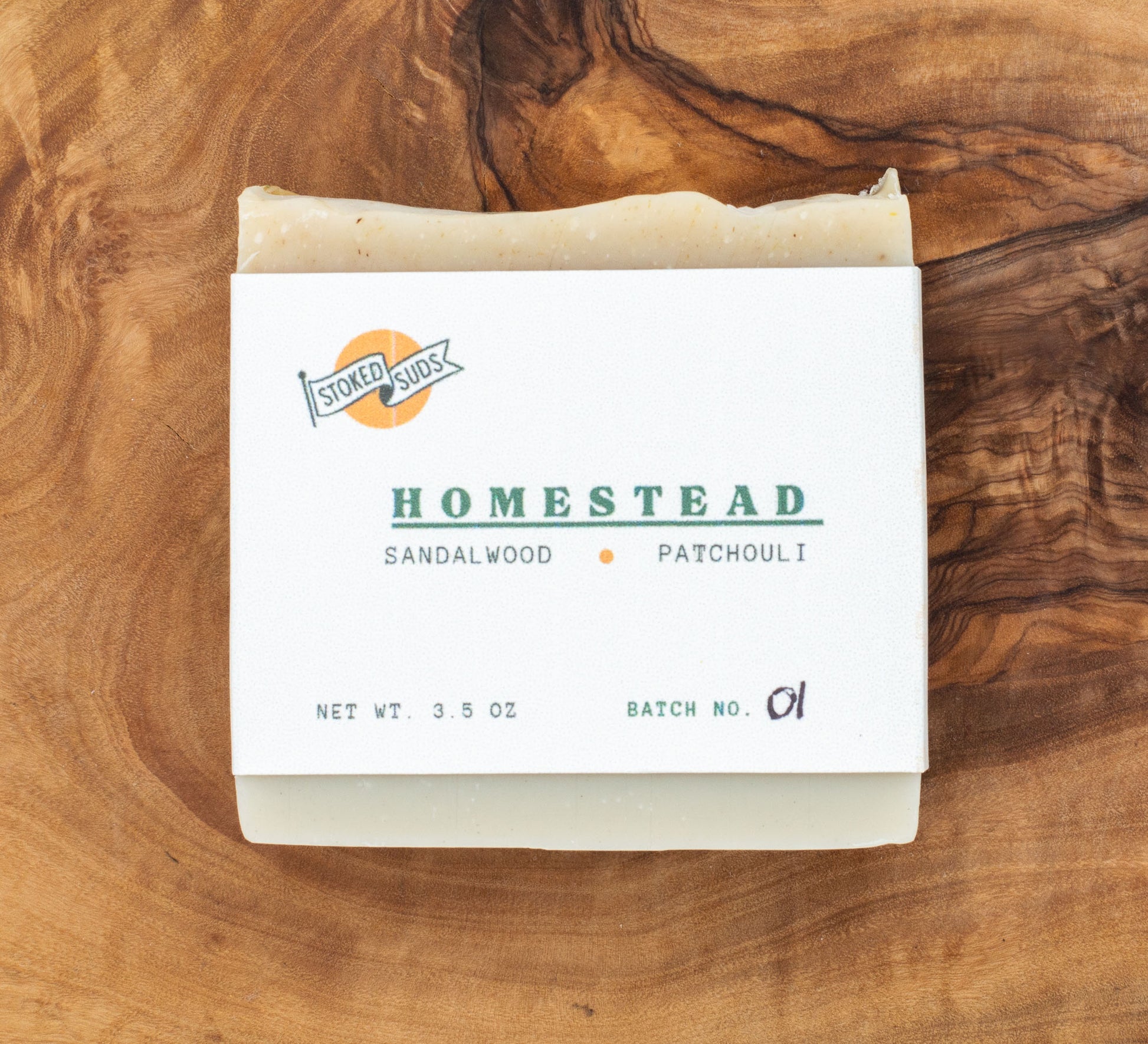 Bar of soap with 'Homestead' label on a wooden surface