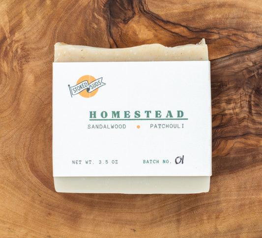 Bar of soap with 'Homestead' label on a wooden surface