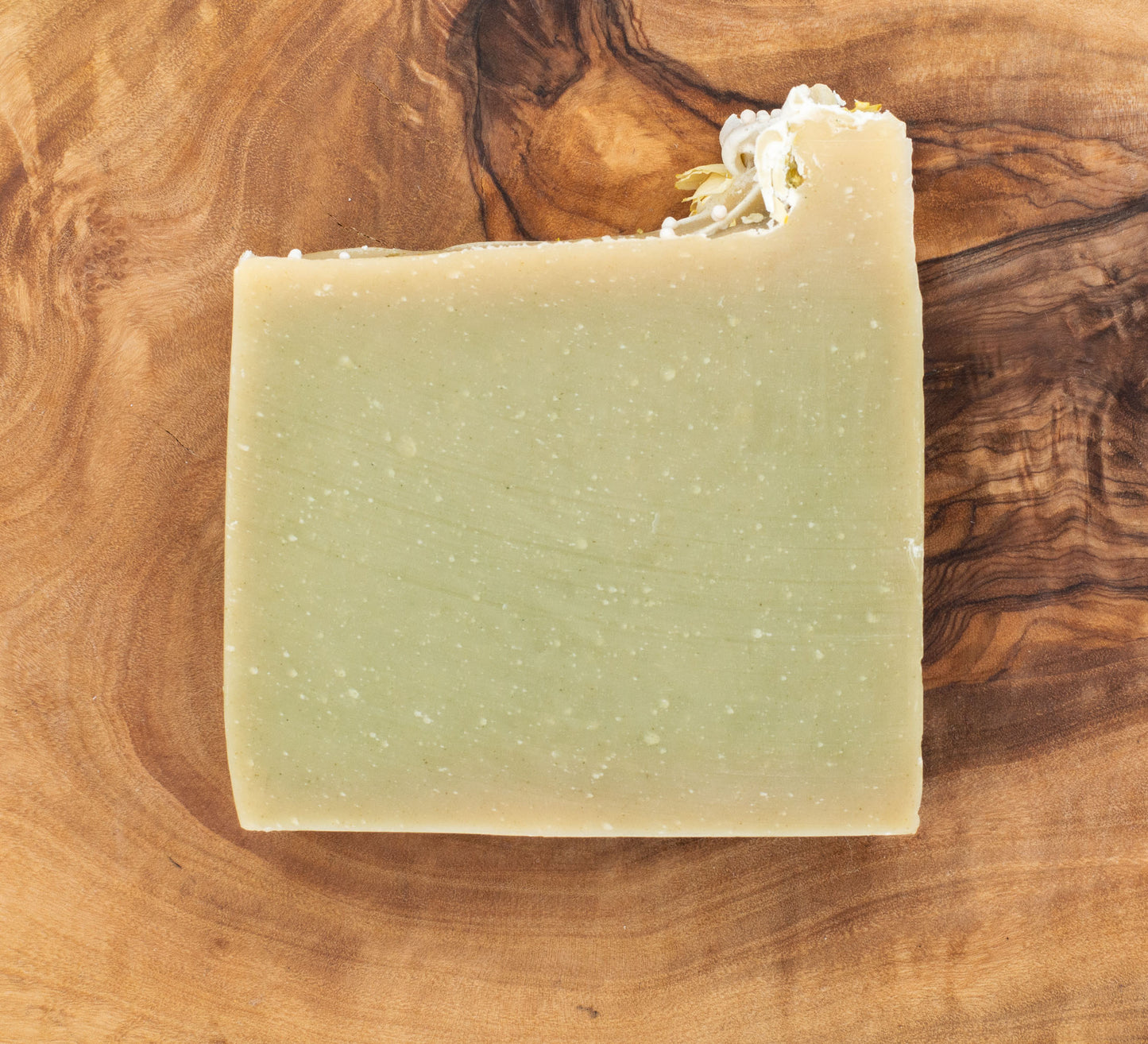 Bar of soap with flowers on a wooden surface