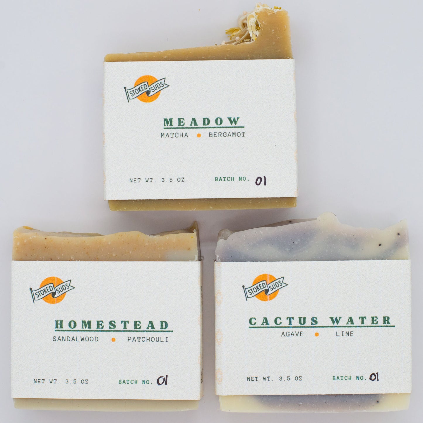 Three bars of different soap with labels on a white background