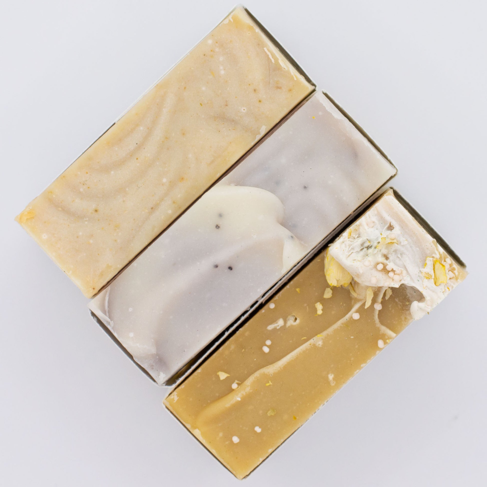 Three different types of soap bars on a light gray background