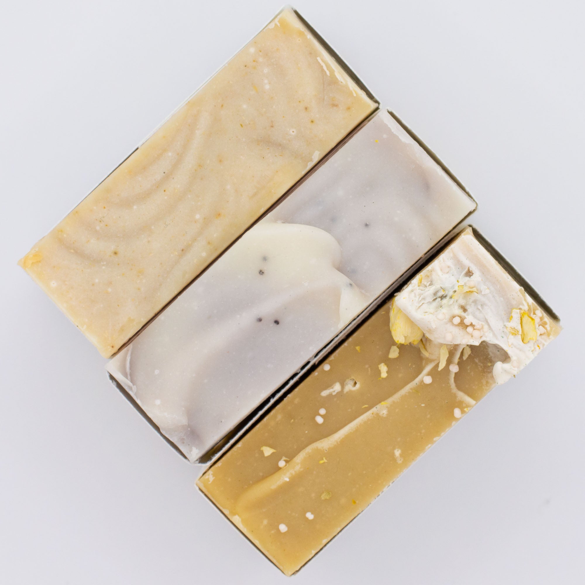 Three different types of soap bars on a light gray background